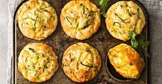 several muffins are on a baking tray with some garnish in the middle