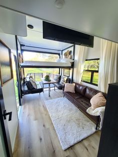 a living room filled with furniture and a bunk bed in the corner next to a window