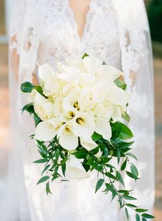 a bride holding a bouquet of white flowers