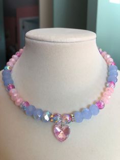 This aurora borealis pink heart charm choker stuns with pink and blue crackle glass beads, light blue aurora borealis faceted glass beads, and light pink faceted glass beads. This piece is exquisite in its ability to reflect light and color. Pink Crystal Necklace With Heart Charm, Pink Heart Charm Choker Necklace, Pink Crystal Necklace With Faceted Beads, Pink Crystal Beaded Necklace For Gift, Pink Heart Beads Choker Jewelry, Pink Aurora Borealis, Pink Aurora, Blue Aurora, Crystal Bead Jewelry