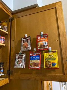 several packets of food are hanging on the wall in front of some shelves with other items