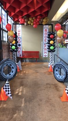 the entrance to an office decorated with balloons and race track decorations for birthdays or baby showers