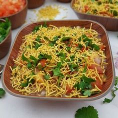 several bowls filled with food on top of a white table covered in condiments