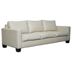 a white leather couch with black legs