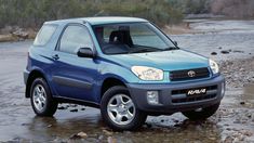 a blue toyota rav4 is parked in the water