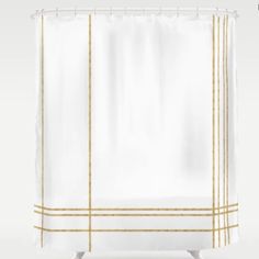 a white shower curtain with gold lines on it