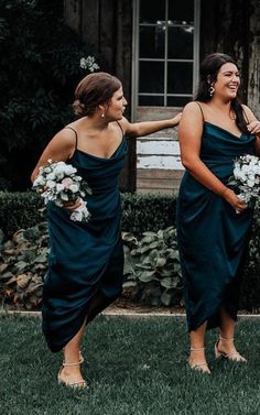 two bridesmaids in dark green dresses laughing together