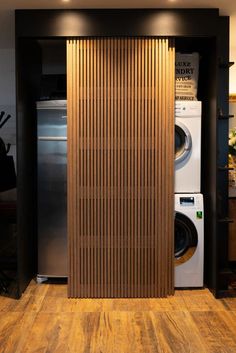 a washer and dryer in a room with wooden slats on the wall