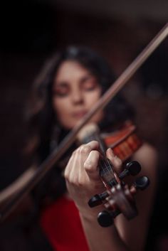 a woman in a red dress holding a violin