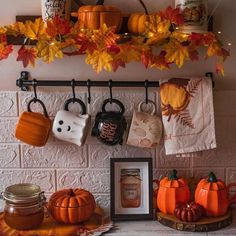 the kitchen counter is decorated with pumpkins and other autumn decorations, including mugs