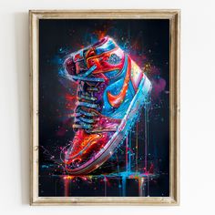 a painting of a pair of sneakers on display in a gold frame with colorful paint splatters