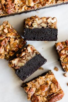 chocolate brownies with nuts and pecans are arranged on a white surface, ready to be eaten