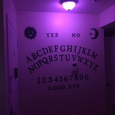 the purple light is shining on the wall in the room with the letters and numbers