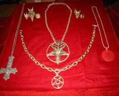 a red velvet table topped with lots of different necklaces and crosses on it's sides