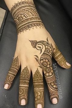 henna tattoo on the palm of a woman's hand, with intricate designs