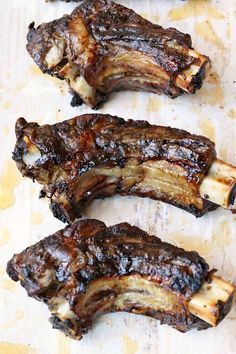 three pieces of meat sitting on top of a cutting board