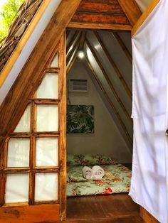 an open door leading to a bed in a loft