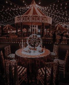 a carousel ride at night with lights on the ceiling and tables set up for an event