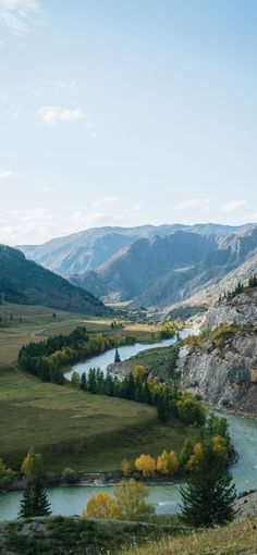 a river running through a valley surrounded by mountains