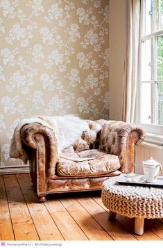 a chair and ottoman in front of a window