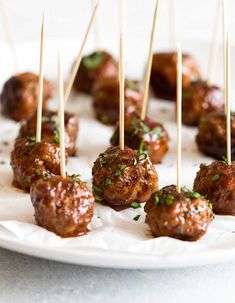 small meatballs with toothpicks on a white plate, ready to be eaten