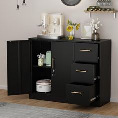 there is a black cabinet with drawers and a clock on the wall