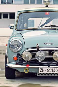 an old blue car parked in front of a building