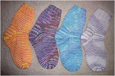 four pairs of knitted socks sitting next to each other