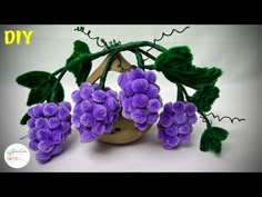 purple flowers are in a basket with green leaves on the top and below it is an ornament that says diy