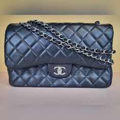 Preowned Chanel Classic Black/Burgundy Double Flap Lambskin Quilted Chain Strap Shoulder Bag. This Bag Can Be Also Worn Crossbody. Size: Large/Jumbo. Measurements: 12"W/8"H/3.5"D Condition: Please Note This Bag Has Moderate Signs Of Wear Which Includes Scuffing, Indentations, Creasing, And Discoloration. We Are A Reseller. We Do Not Possess Any Information Of The History Of The Bag. We Do Not Know If The Bag Was Repaired Or Repainted. It Does Not Seem So To The Naked Eye. Exterior: There Are Scuffs Throughout The Bag. Can Be Seen On The Exterior Flap. There Are Several Scuffs On The Base Of The Bag. There Are Also Scratches On The Exterior That Can Be Seen Throughout. There Are Pe Flap Shoulder Bag, Shoulder Bag Black, Chain Strap, Chanel Bag, Chanel Classic, The History, Classic Black, Chanel, Bag Lady