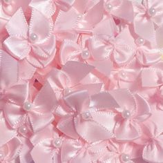 a pile of pink bows with pearls on them