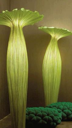 two tall green vases sitting next to each other