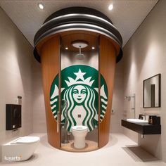 there is a bathroom with a starbucks sign on the wall and a toilet in it