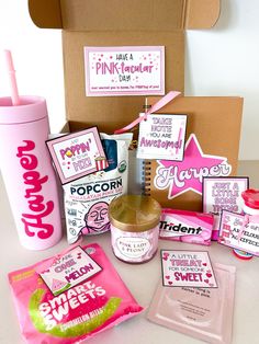 the contents of a pinkie box are displayed on a white counter top, next to a cup and other items