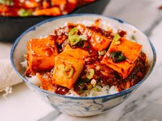 a bowl filled with rice and tofu on top of a table