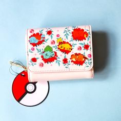 a wallet with a pokemon keychain hanging from it's front pocket on a blue background