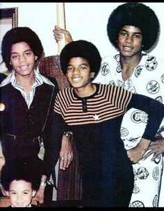 an old photo of some people posing for a picture with one person holding a baseball bat