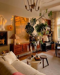 a living room filled with furniture and plants