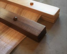 two pieces of wood sitting next to each other on top of a table with buttons