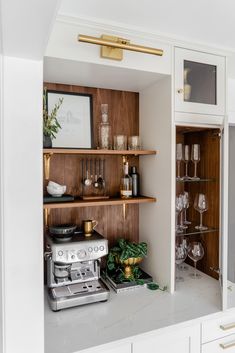 a kitchen with wooden shelves and glassware on the counter top in front of it