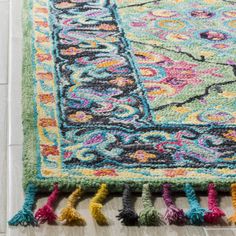 a multicolored rug with tassels on the floor