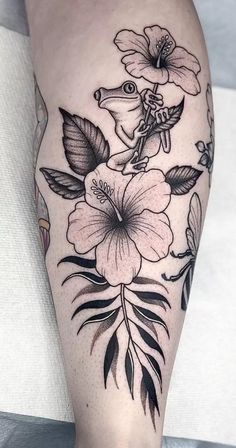 a woman's leg with flowers and leaves on it