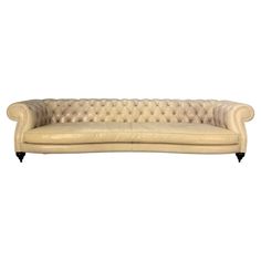 a cream colored couch with black legs and tufted upholstered backrests