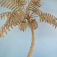 a palm tree made out of wicker and other items is shown against a blue background