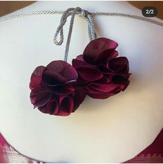 two flowers are attached to a necklace on a mannequin's neckline