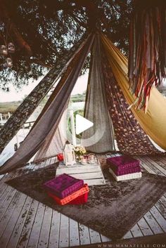 there is a hammock set up on the deck with pillows and rugs