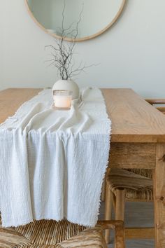 a table with a white cloth on it and a mirror in the backround