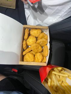 a box filled with chicken nuggies next to french fries