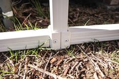 a close up of a window frame on the ground with grass in front of it