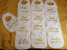 six baby bibs with different sayings on them sitting on top of a table